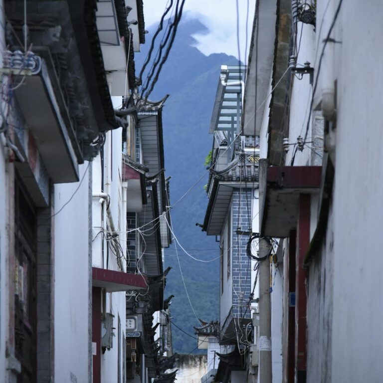 Explore the narrow alleyways of Lijiang, offering a glimpse of traditional Chinese architecture amidst the mountains.
