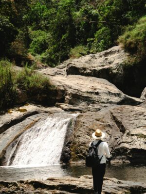 Man in nature admiring a waterfall in Cuetzalan, Mexico.