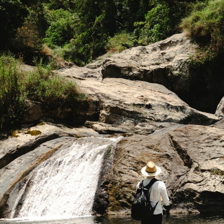 Man in nature admiring a waterfall in Cuetzalan, Mexico.